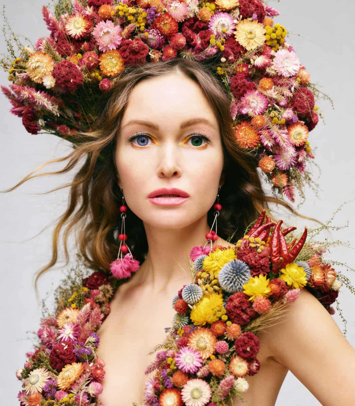 Woman with floral crown and accessories, vibrant flower arrangement, fashion, beauty, floral art.